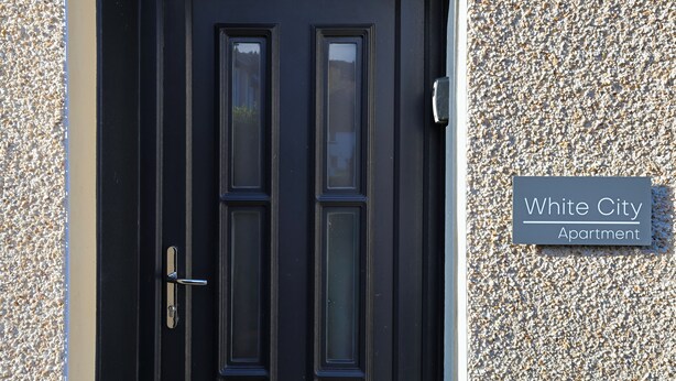 A black door with a sign reading "White City Apartments". - The White City Apartment (Oban)