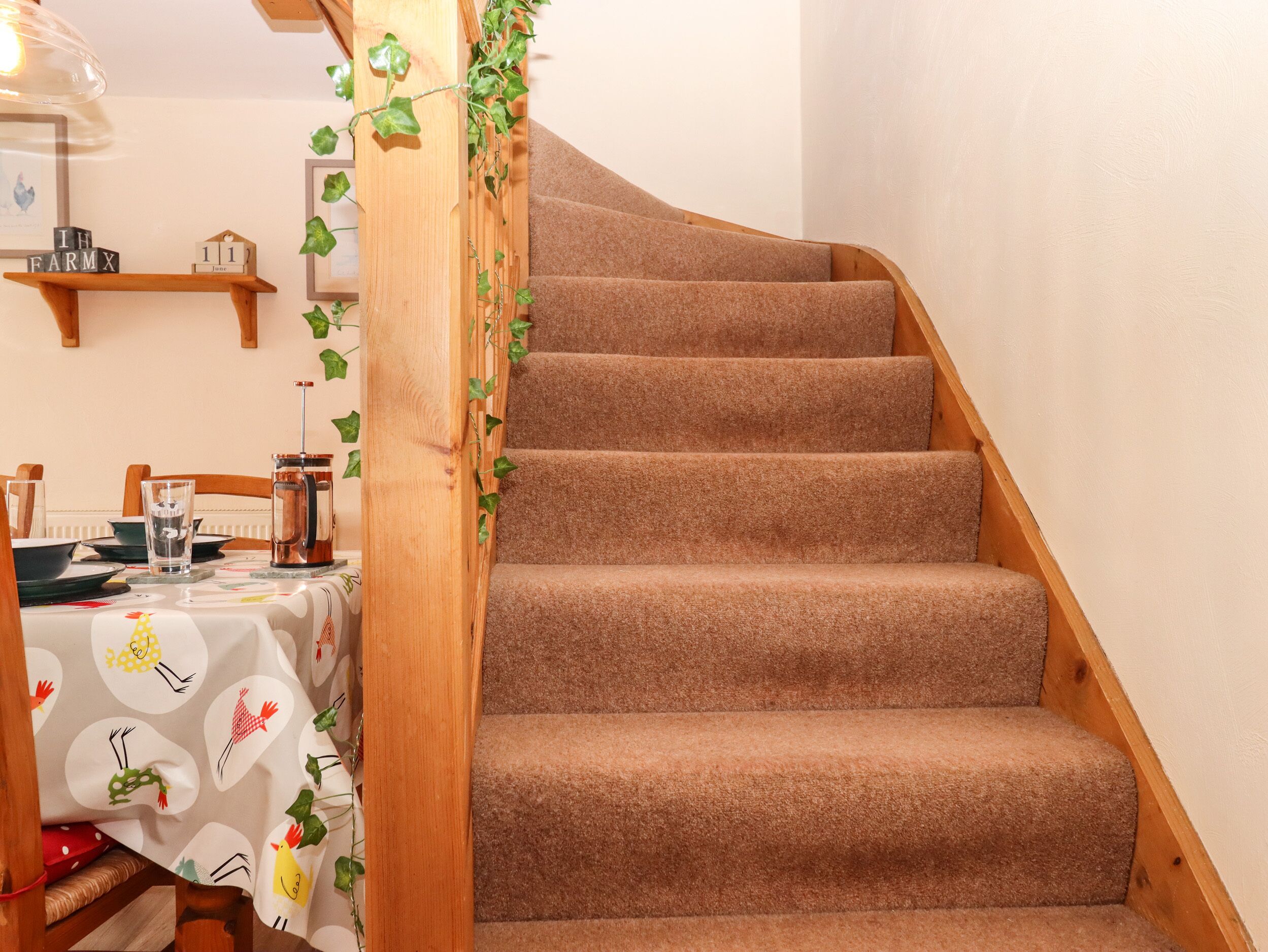Eine Treppe mit Teppichstufen und Holzhandläufen, die zu einer oberen Etage führt.