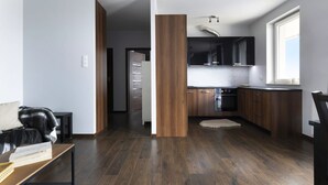 Een moderne keuken met donkerhouten kastjes, een inbouwoven en een raam dat voor natuurlijk licht zorgt.
