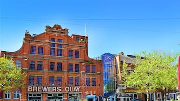 Punatiilinen rakennus, jonka yläpuolella on kyltti, jossa lukee ”BREWERS QUAY”, ja sen vieressä sijaitseva lasiseinäinen rakennelma.