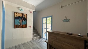 Ein Flur mit einer hölzernen Bank, einer Treppe und einem Gemälde an der Wand.