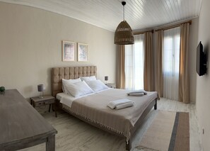 A bedroom with a large bed, a bedside table, a lamp, a hanging light fixture, and a television on the wall. - La Luna Boutique Hotel - Alacati Reisdere (Cesme)