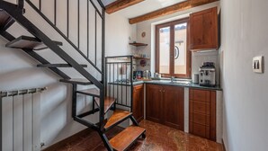 A kitchen with wooden cabinets, a built-in oven, and a coffee machine. - Le terrazze nel cuore della Kalsa by Wonderful Italy (Palermo)