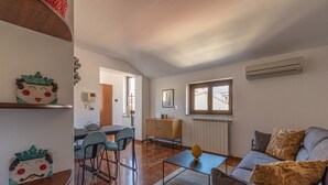 A modern living room with a sofa, coffee table, and a dining area with chairs and a table. - Le terrazze nel cuore della Kalsa by Wonderful Italy (Palermo)