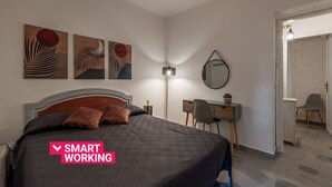 Una camera da letto moderna con un letto, una scrivania e opere d'arte alle pareti.