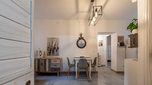 Zona pranzo con un mobile in legno, una sveglia e un tavolo con sedie.