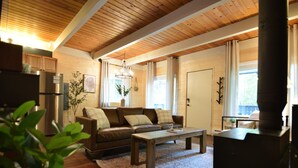 Un salon chaleureux avec un plafond en bois, un canapé, une table basse et une cheminée.