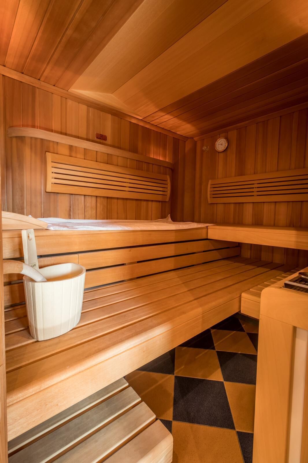 A sauna with wooden benches and a tiled floor.