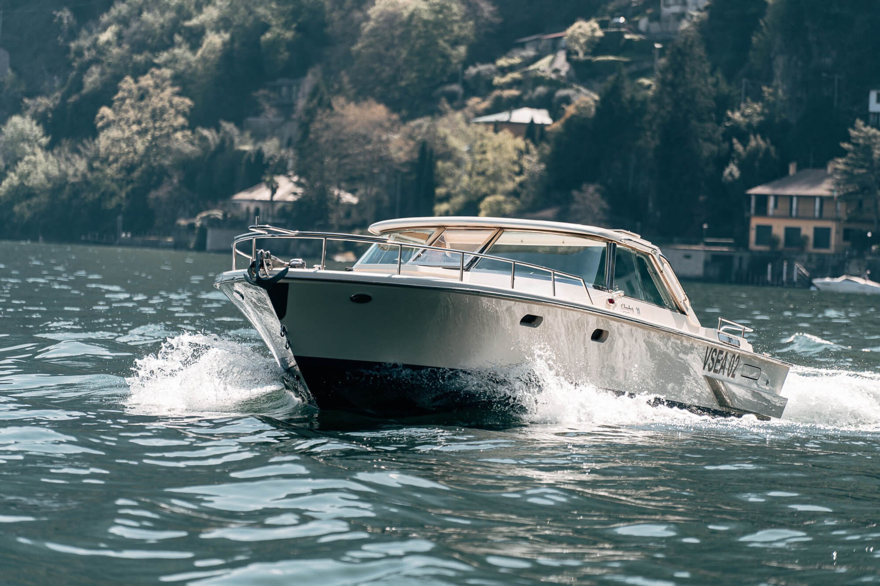 Ein Boot fährt auf dem Wasser, im Hintergrund ein Haus.