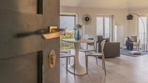A modern living room with a dining area, large windows, and a view of the outdoors.