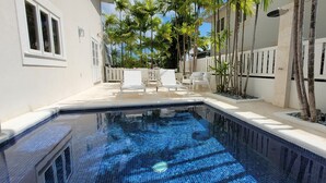A swimming pool with tiled flooring, surrounded by white walls and a white fence. - Beautiful  4BR villa w/pool in St James, Porters.  5 min walk to gorgeous beach. (Porters)