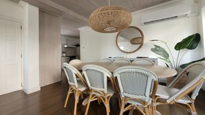 A dining area with a round table surrounded by wicker chairs, a woven pendant light, and a large mirror on the wall. - Beautiful  4BR villa w/pool in St James, Porters.  5 min walk to gorgeous beach. (Porters)