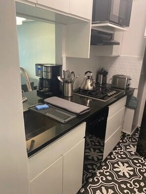 Prepare meals in this kitchen with a coffee maker, kettle, toaster, and stove.