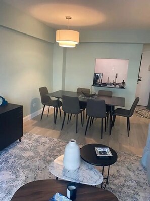 Enjoy meals in this dining area with a rectangular table and six chairs, illuminated by a pendant light.