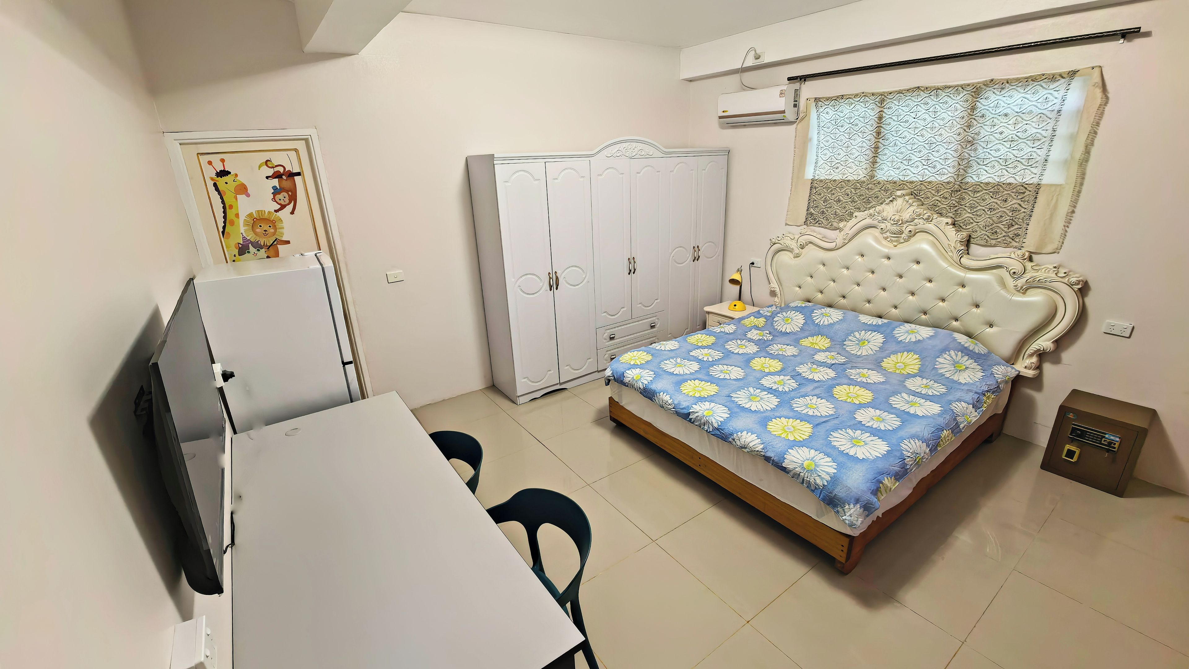 A bedroom with a bed, a wardrobe, a desk, and a chair.