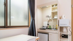 A compact kitchen with a refrigerator, a sink, and a microwave. - K HOUSE - E JOY INN Okubo Branch (Tokyo)