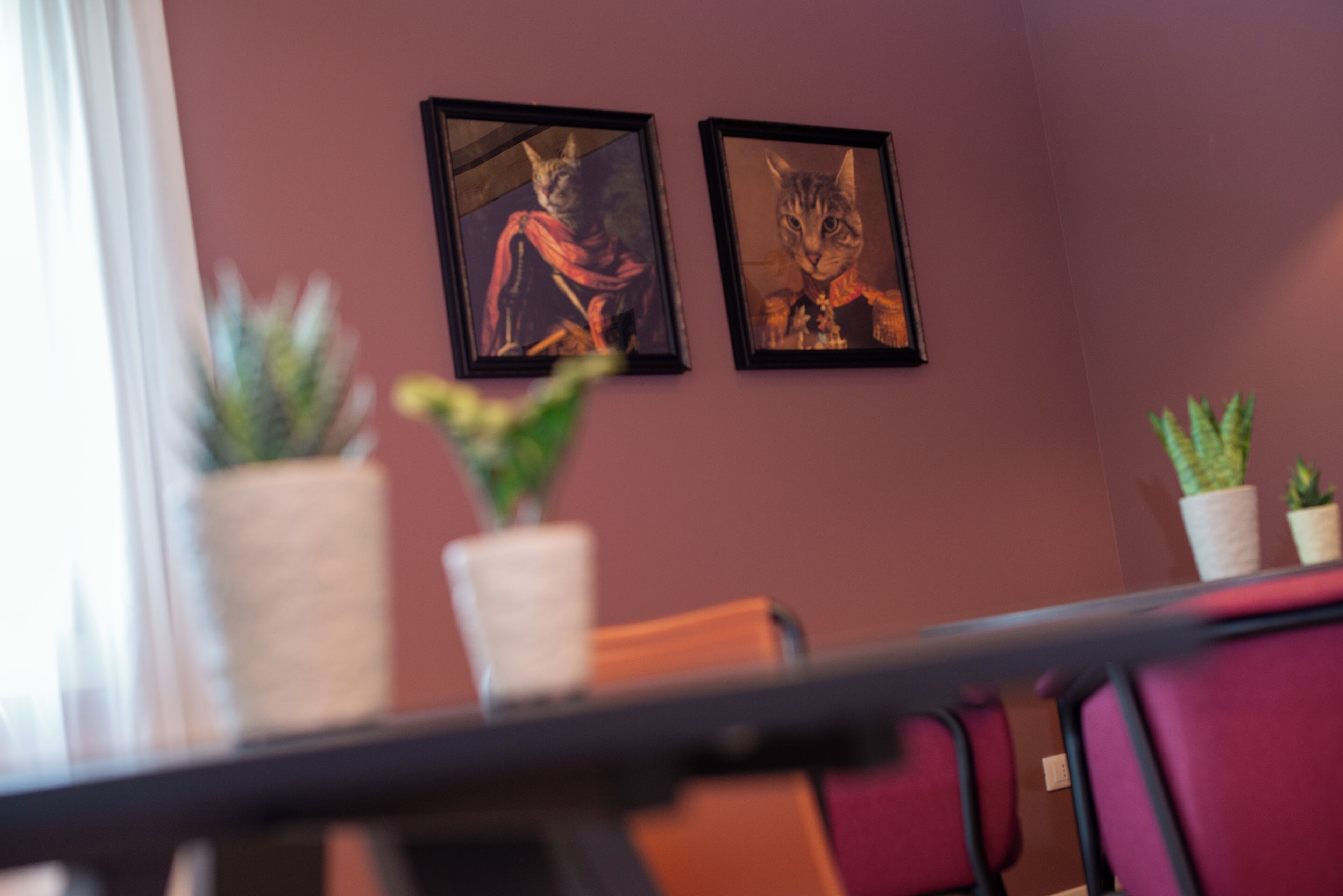 Une salle de conférence avec une table, des chaises et deux tableaux encadrés au mur.