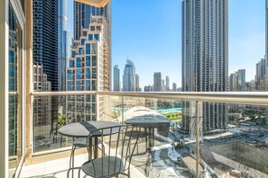 A balcony with a glass railing, two chairs, and a table. - Silkhaus Lofts, Downtown Dubai (Dubai)