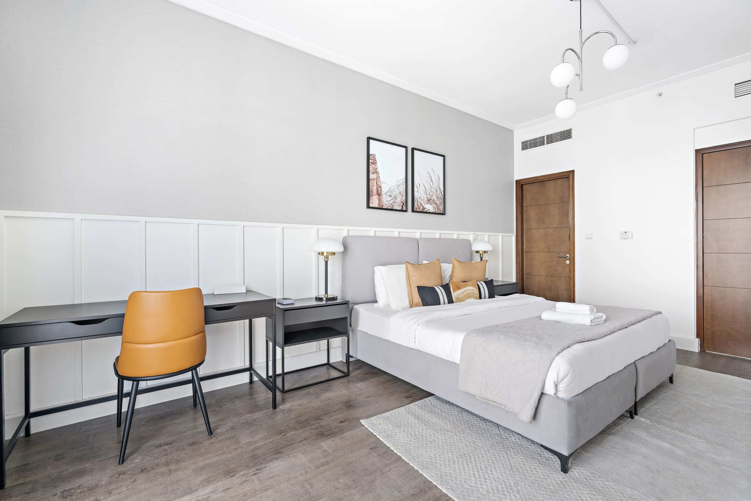 Ein modernes Schlafzimmer mit Bett, Schreibtisch und Stuhl.