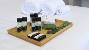 A neatly made bed with rolled white towels, a tray with essential oils, and a mirror on the wall. - ONAR OURANOUPOLIS (Aristotelis)