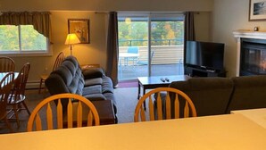 A living room with a sofa, chairs, a TV, and a fireplace. - Penthouse with Mountain Views, Pools & Jacuzzis (Lincoln)