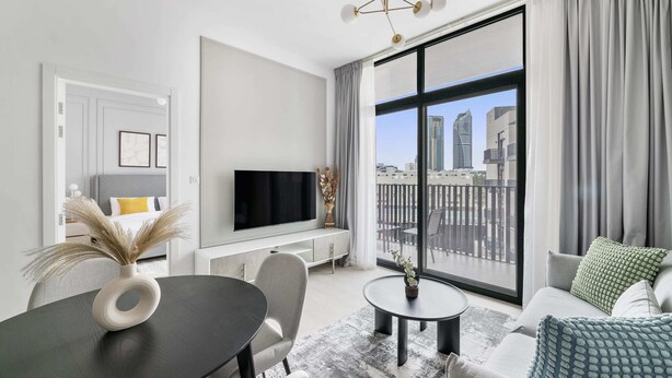 Een moderne woonkamer met een flatscreen televisie, een eettafel en een bank.