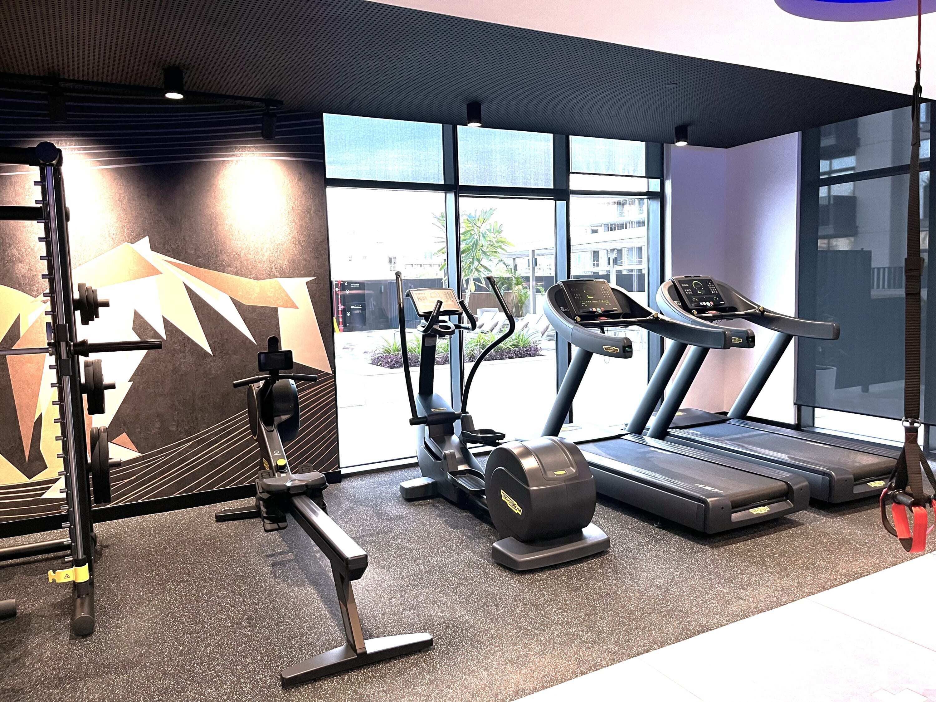 A gym with treadmills, an elliptical, and weight machines.