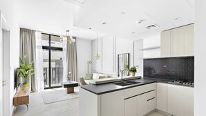 Een moderne keuken met een zwarte spatwand, witte kastjes en een centraal eiland.