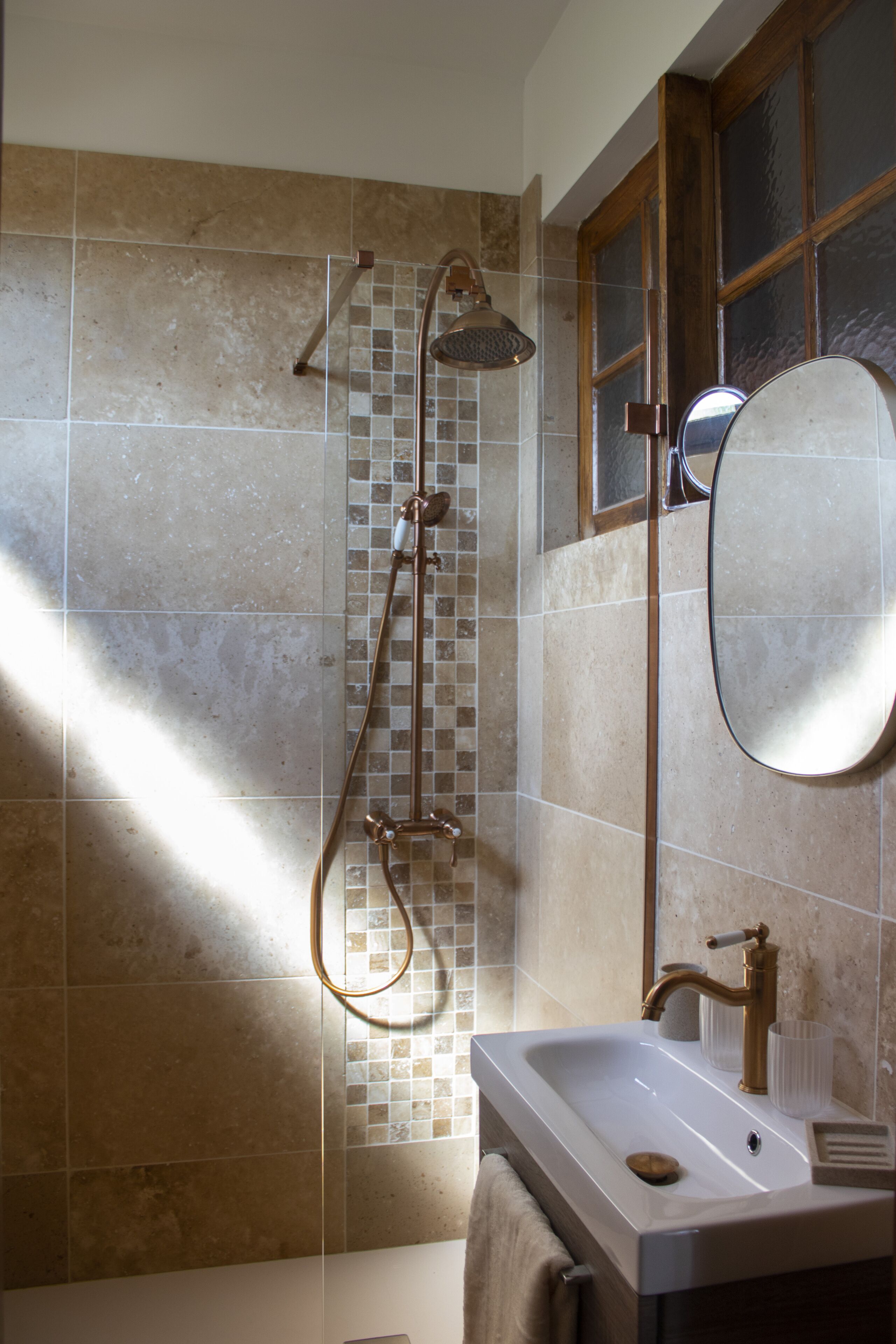 A bathroom with a shower, a sink, and a mirror.