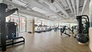 Ein geräumiges Fitnessstudio mit Laufbändern, Kraftgeräten und verschiedenen Trainingsmöglichkeiten.