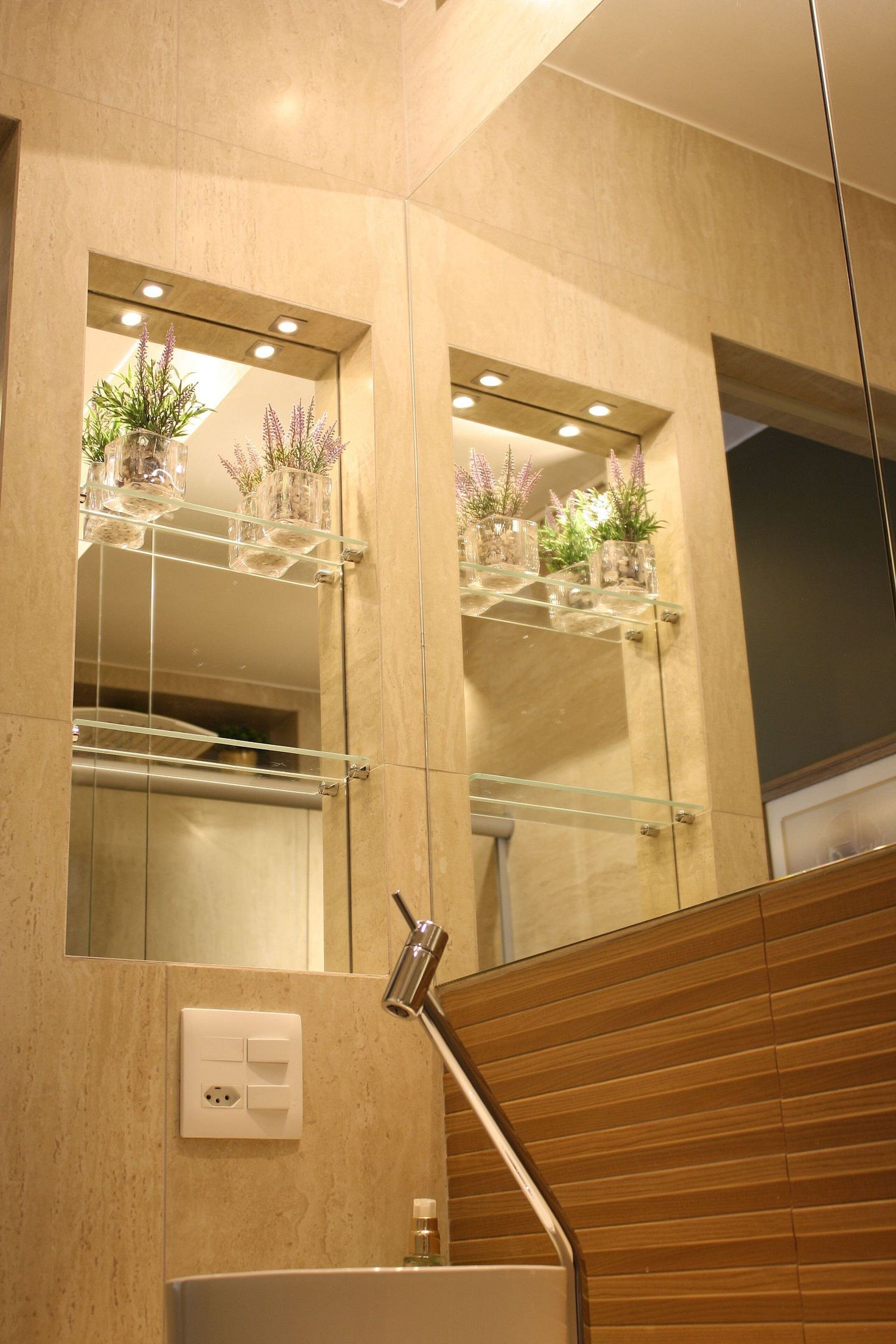 A modern bathroom with a large mirror, glass shelves with plants, a towel rack, and a wooden panel wall.