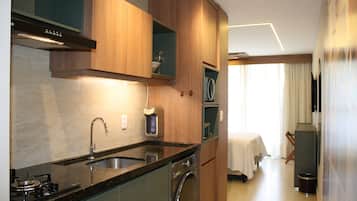 A modern kitchen with a built-in stove, sink, and dishwasher, wooden cabinets, and a dining area with a table and chairs.