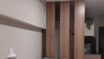 Un interior moderno con un comedor amueblado con madera y una cocina con armarios y electrodomésticos.