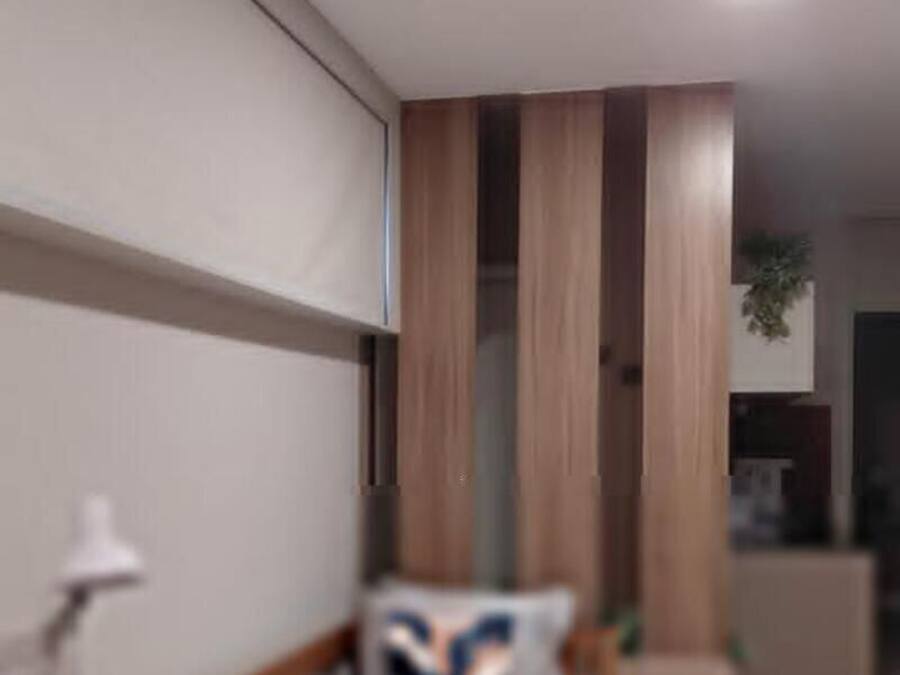 Un interior moderno con un comedor amueblado con madera y una cocina con armarios y electrodomésticos.
