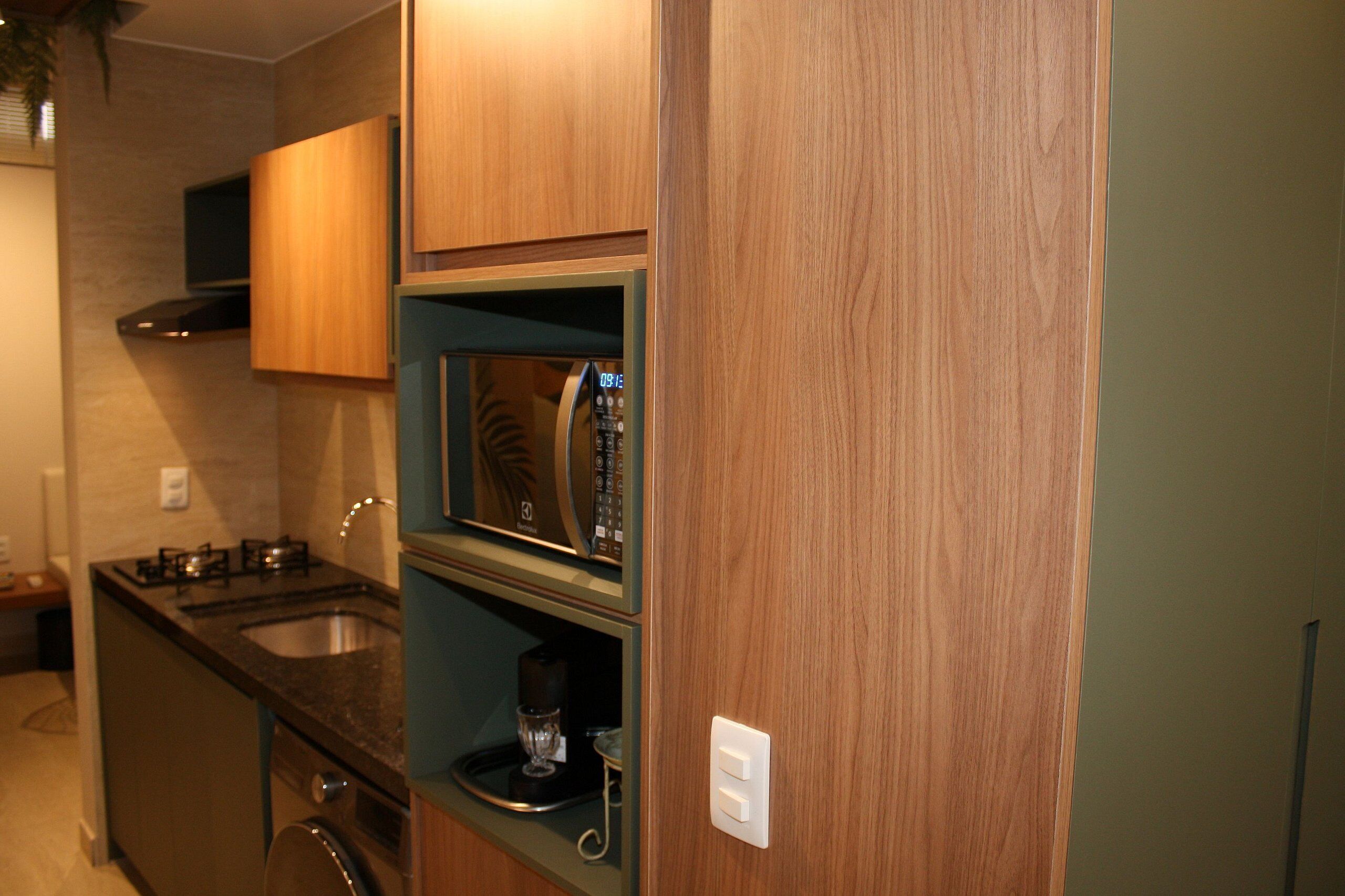 A compact kitchen with a microwave, stove, and sink.