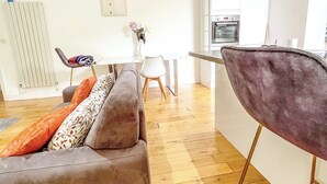 Una sala de estar moderna con un sofá, una mesa de comedor y una zona de cocina.