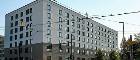 Un edificio moderno de varios pisos con fachada gris y numerosas ventanas.