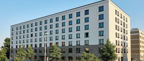 A modern hotel with a flat facade, multiple floors, and a row of windows on each level.