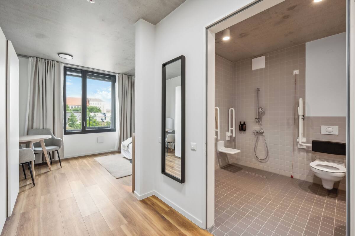 A modern bathroom with a shower, toilet, and sink.