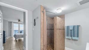 Ein modernes Badezimmer mit barrierefreier Dusche, Toilette und Handtuchhalter.