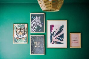 A wall with five framed artworks, including a tiger, a zebra, and a quote about dancing.