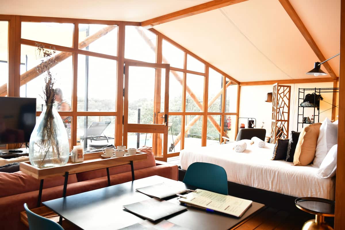 A cozy room with a bed, a desk, and a large window.