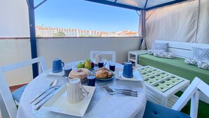 A covered outdoor dining area with a table set for two, featuring a pitcher, cups, and pastries. - ALBUFEIRA SKYLIGHT 1 WITH POOL by HOMING (Albufeira)