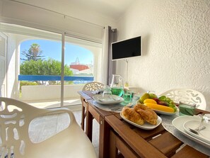 Enjoy meals in this inviting dining area with a table for four, a flat-screen TV, and a window offering a view of the surrounding landscape.