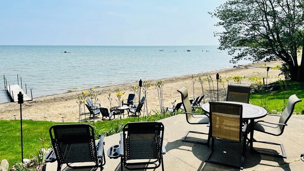 Une terrasse avec des sièges extérieurs donnant sur une plage.