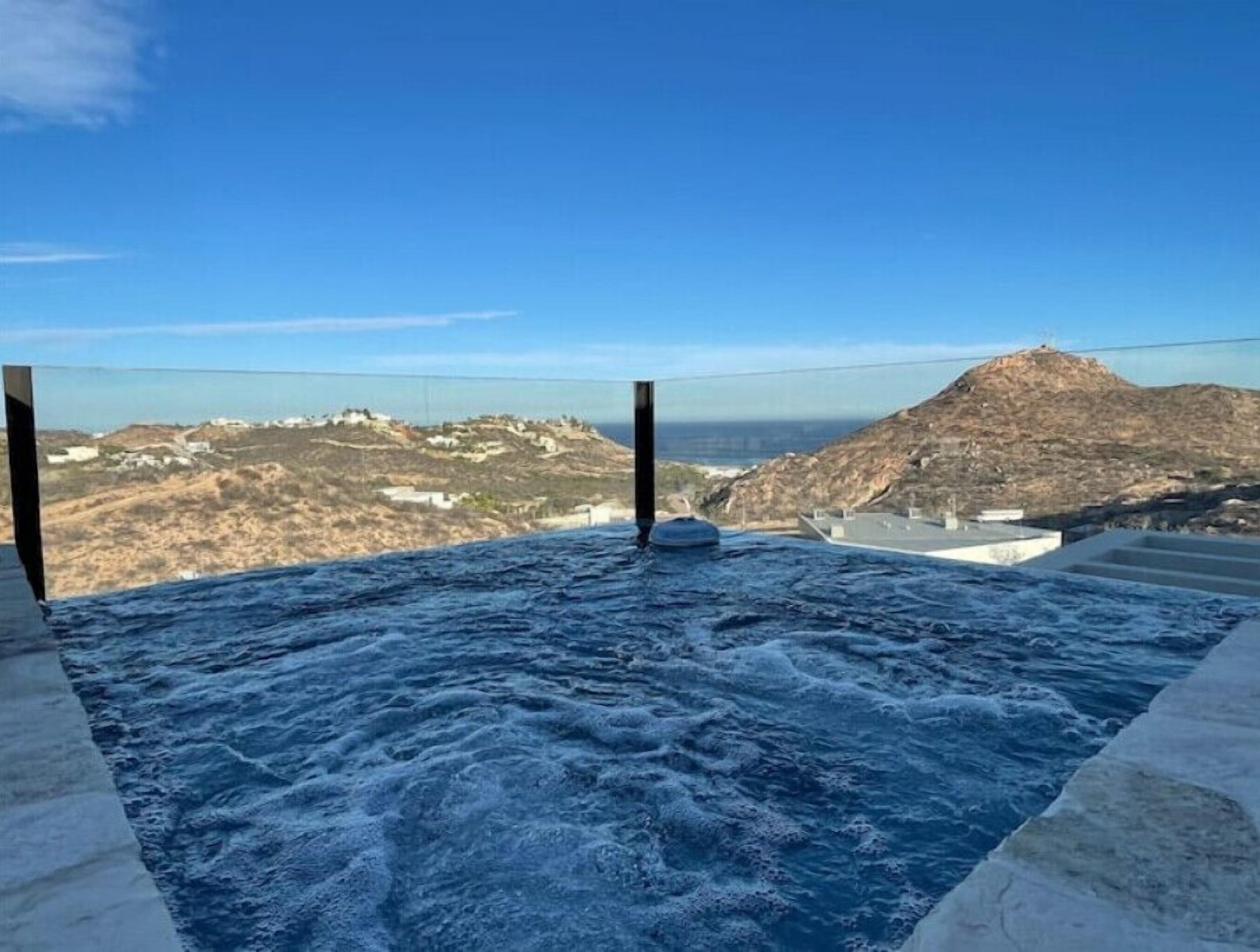 A hot tub with a view of a coastal landscape.