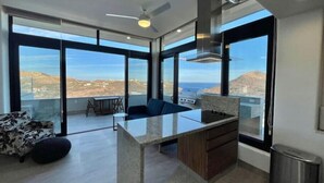 Una cocina moderna con una isla central, ventanas amplias y vistas al paisaje.