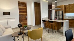 Une cuisine moderne dotée d’un îlot central, de tabourets de bar et d’un four encastré.