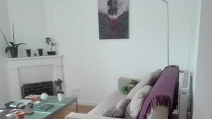 Un salon avec un canapé, une table basse et une cheminée.