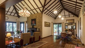 Un salón espacioso con pisos de madera, una chimenea y una zona de comedor con sillas y una mesa.